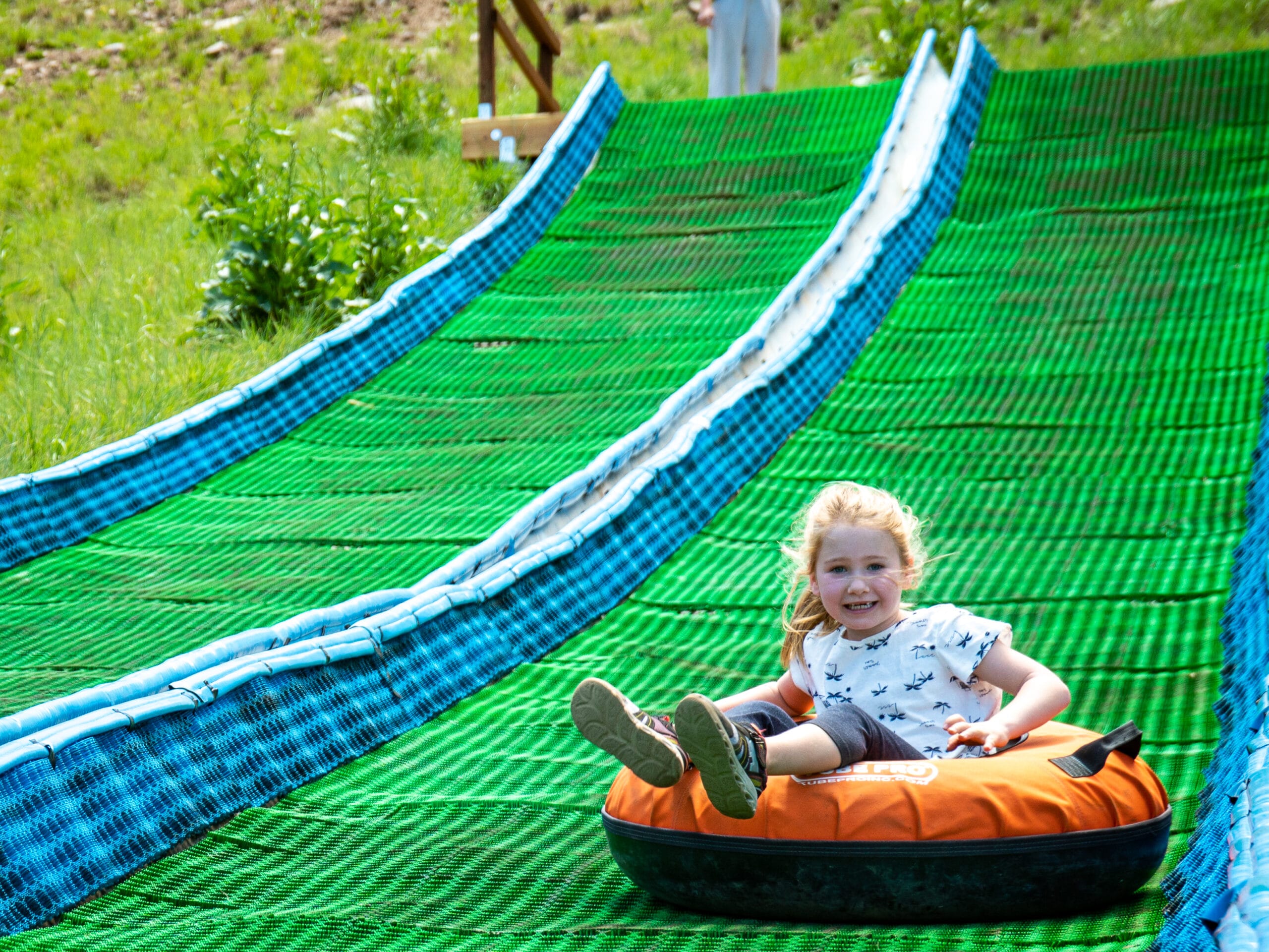 Female child on summer tubing hill at Snowbowl.