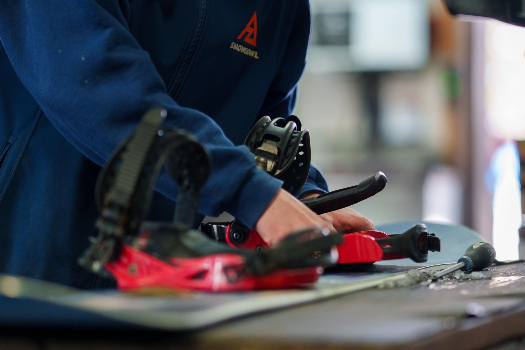 Snowbowl Employee Adjusting a Rental Snowboard