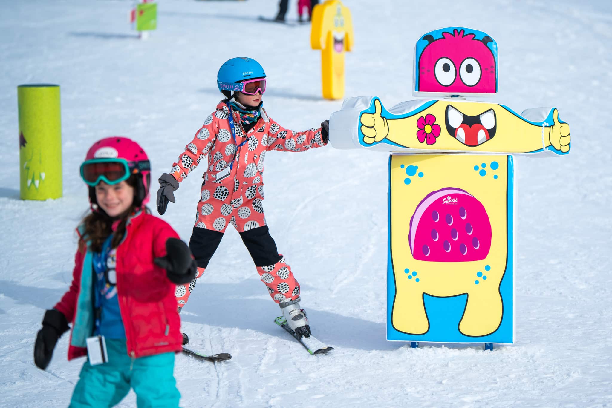 Two young skiers navigating an obstacle course with joy.