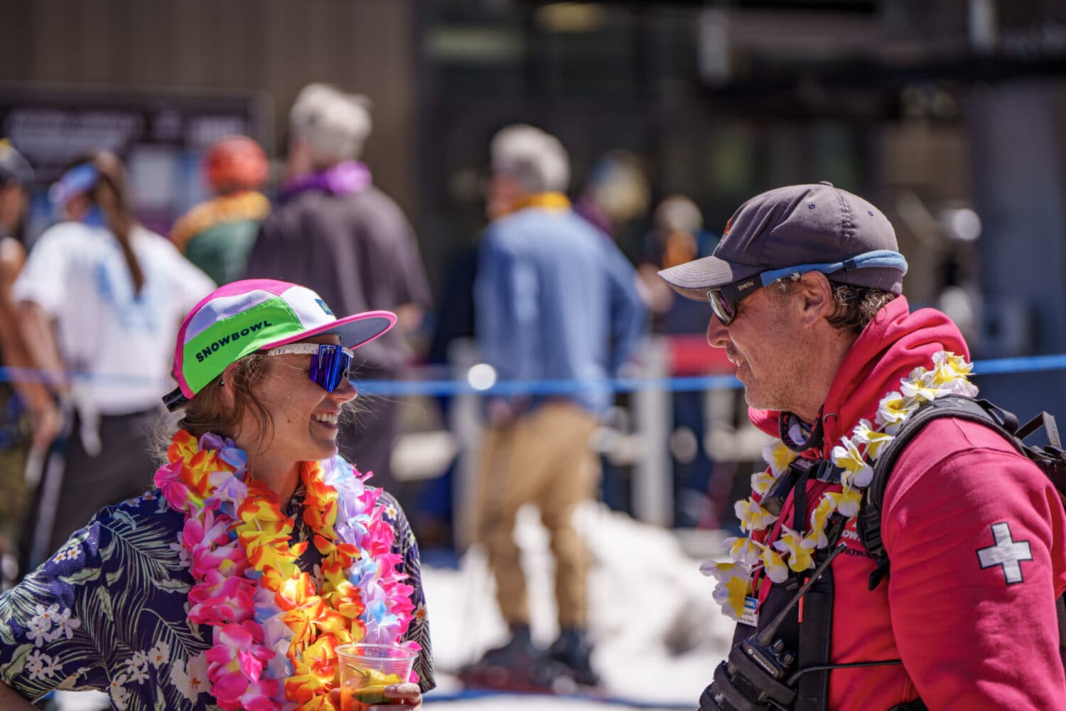 Ski Patrol and a Snowbowl guest talking on the Agassiz deck during spring break