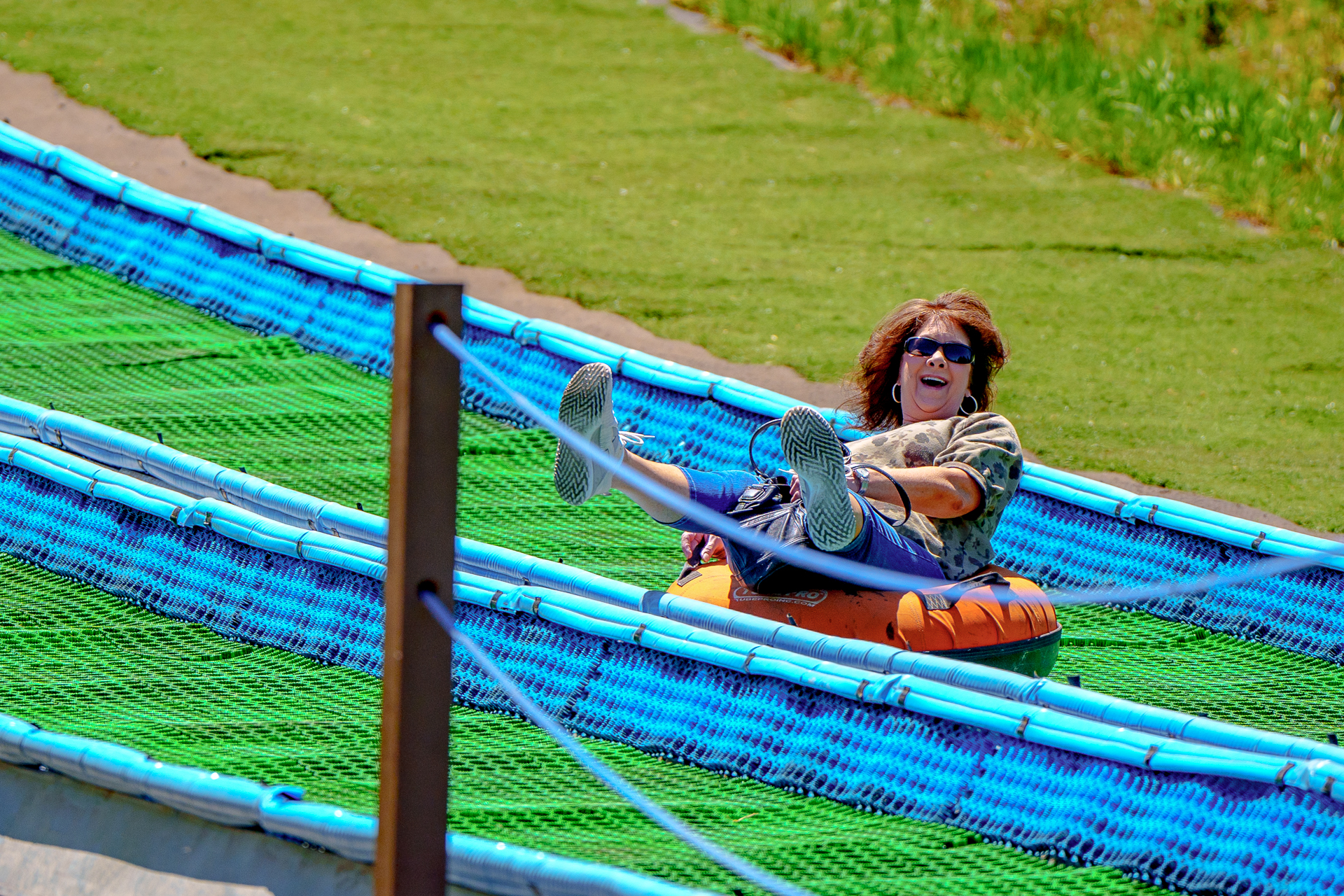 woman cheerfully riding down tubing hill