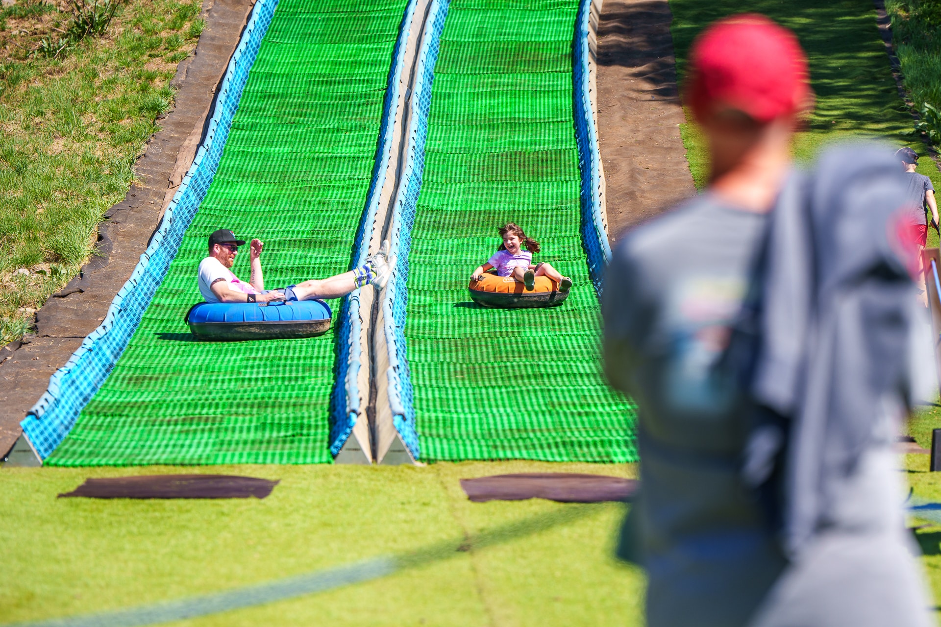 Man watching family ride down tubing hill