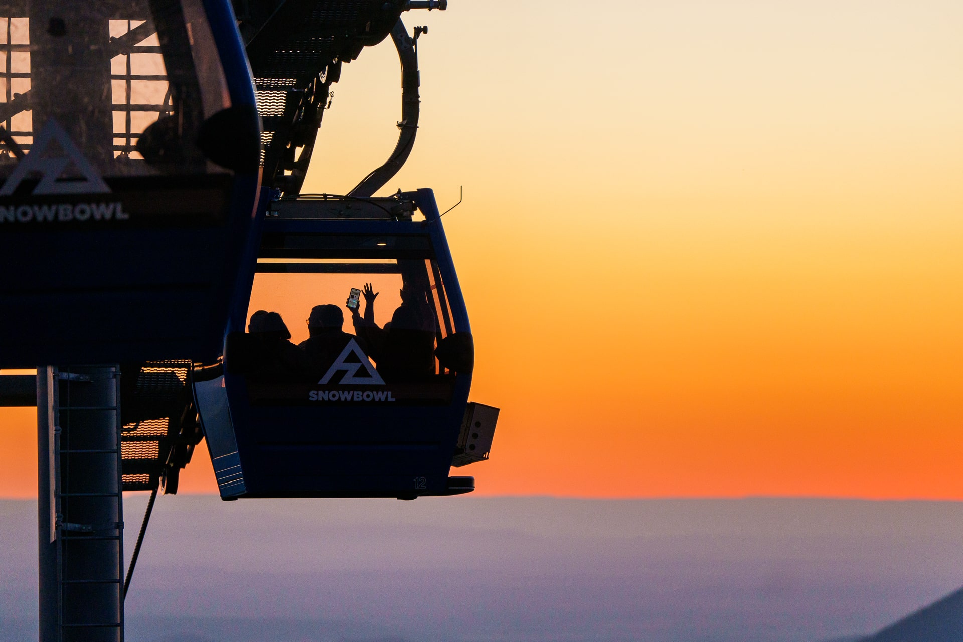 Family riding down gondola after sunset