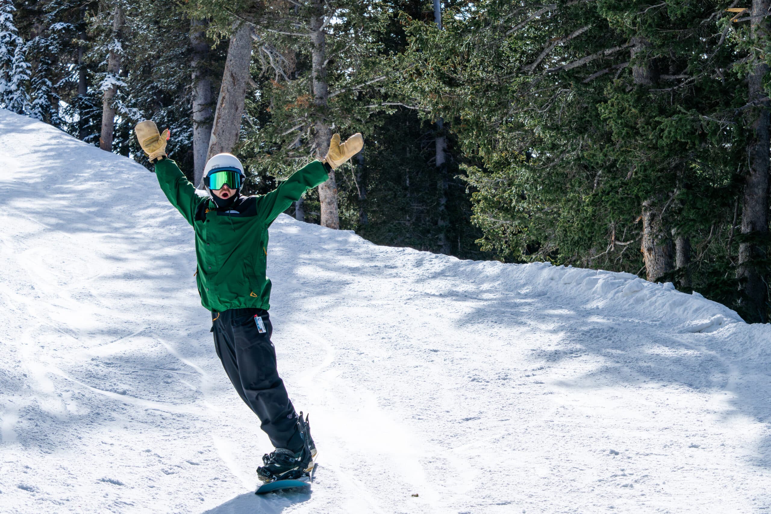 Snowboarder at Snowbowl waving his arms in the air