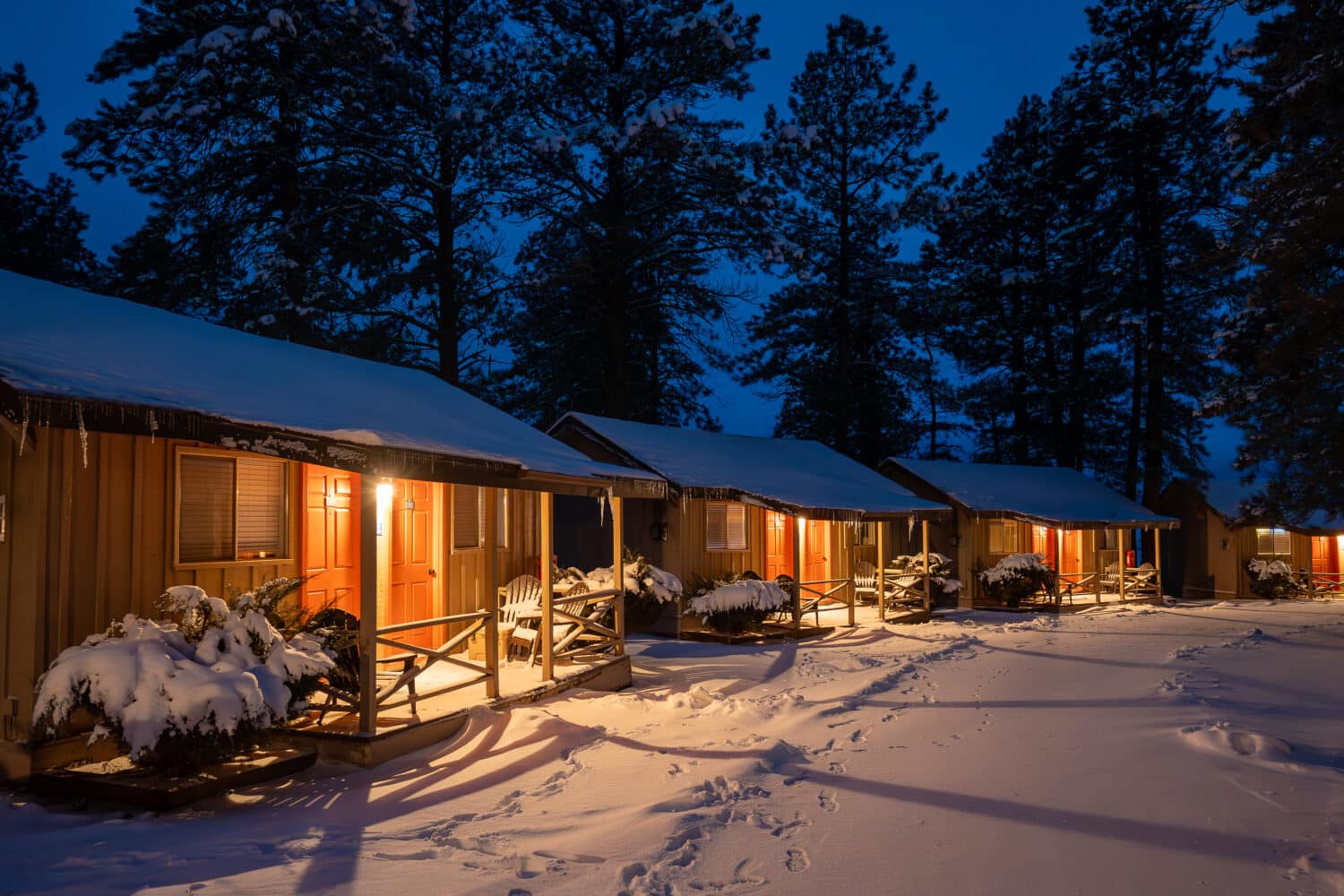 Nighttime view of Basecamp hotel rooms, covered in snow.