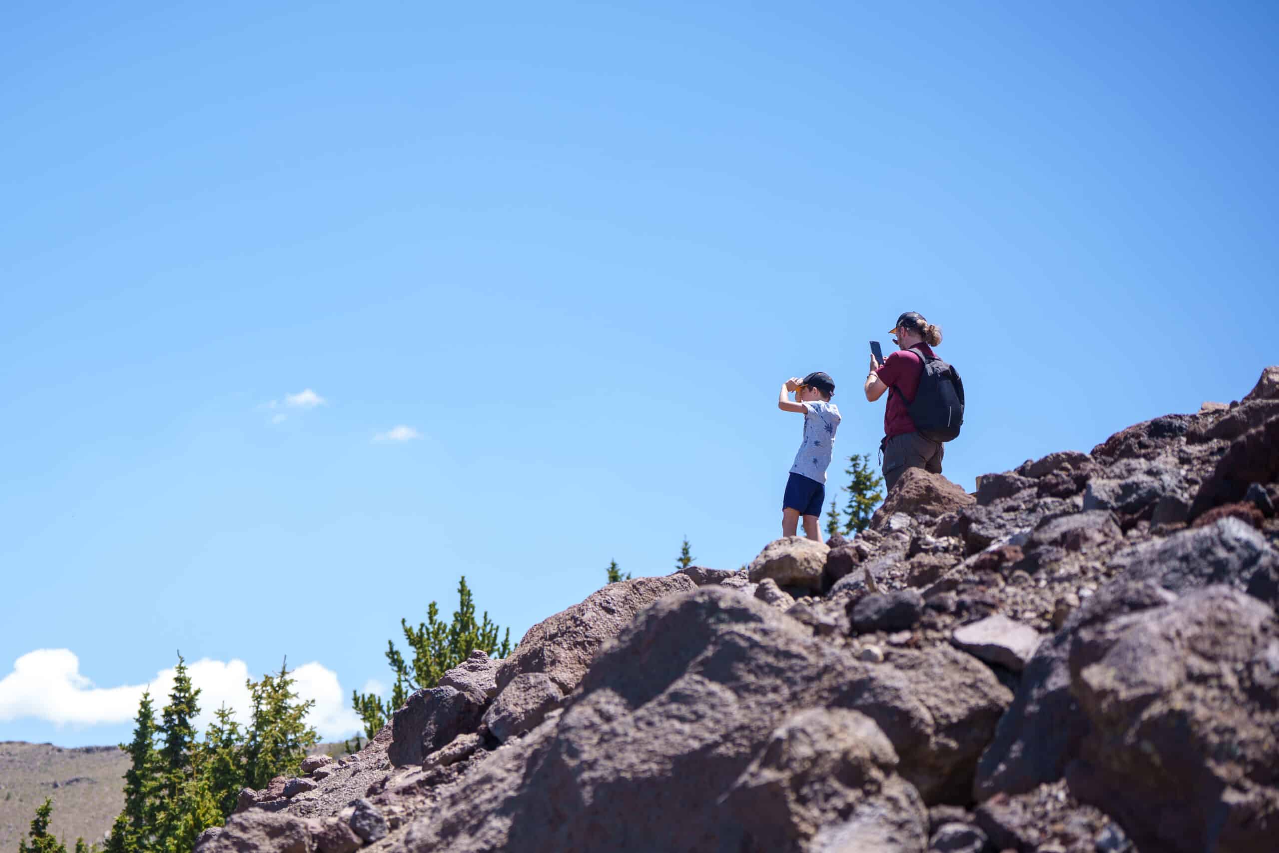 Two hikers at the top of Snowbowl taking pictures of the views