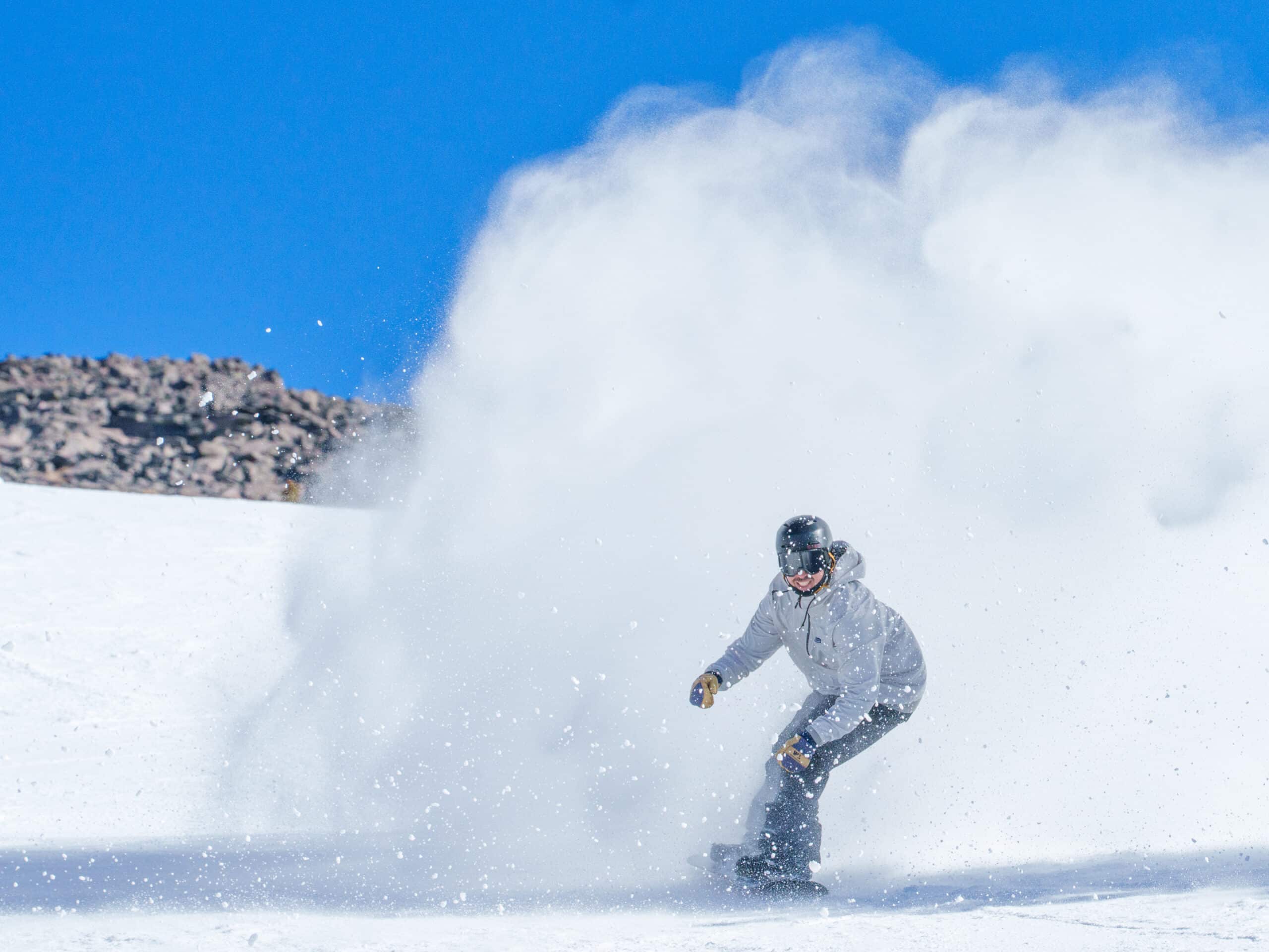 Snowboarder spraying snow and smiling