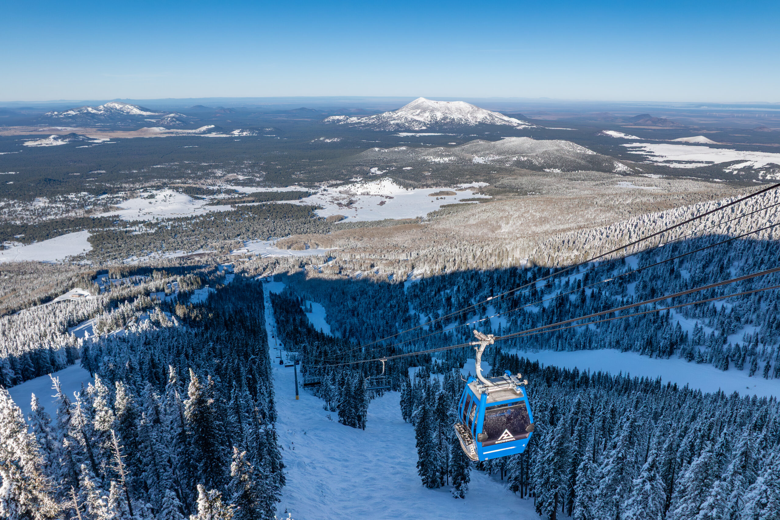 A winter Scenic Gondola Ride ascending the lift line, Arizona winter-scape in the background