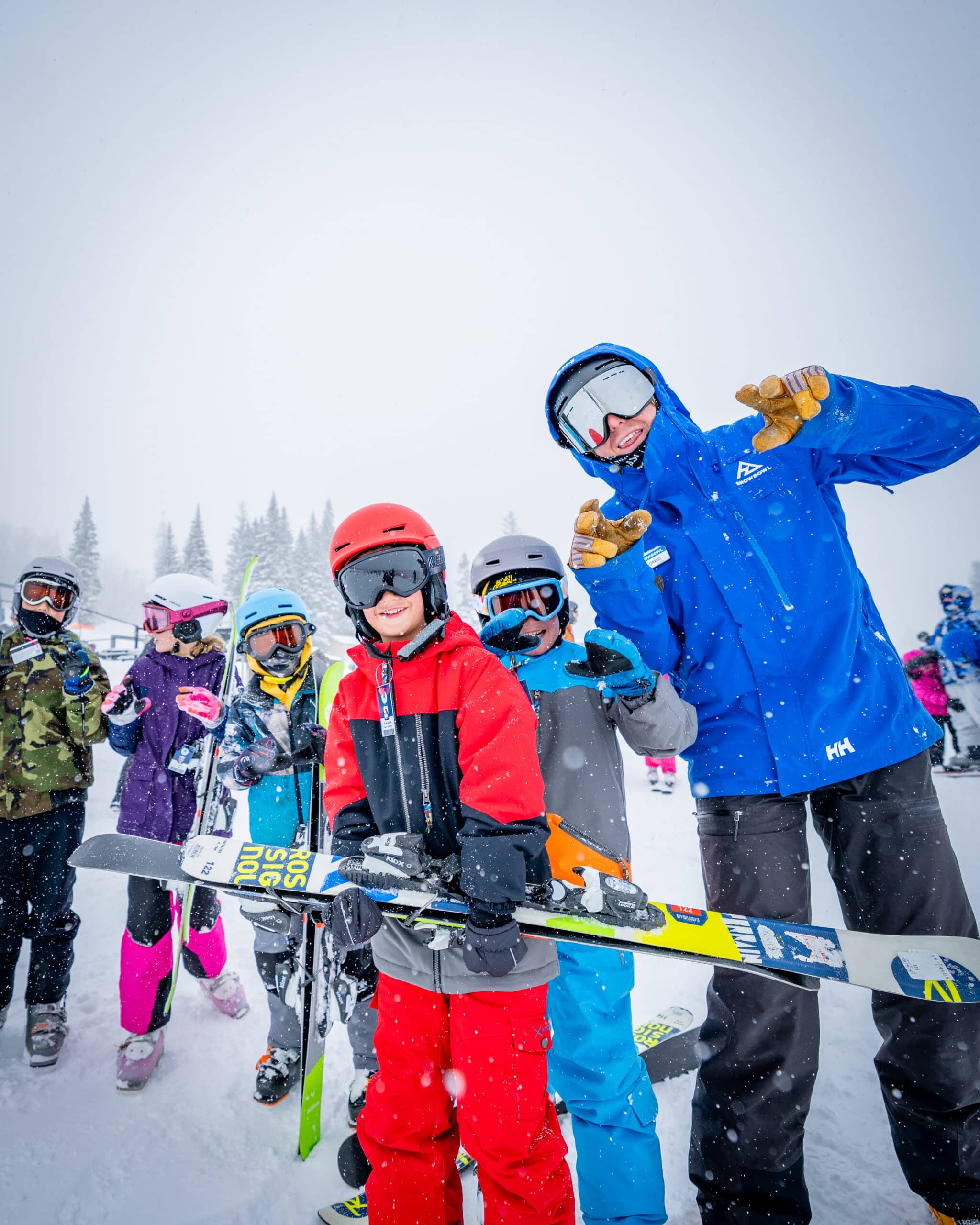 A Snowbowl ski school instructor with a group lesson of children in the snow