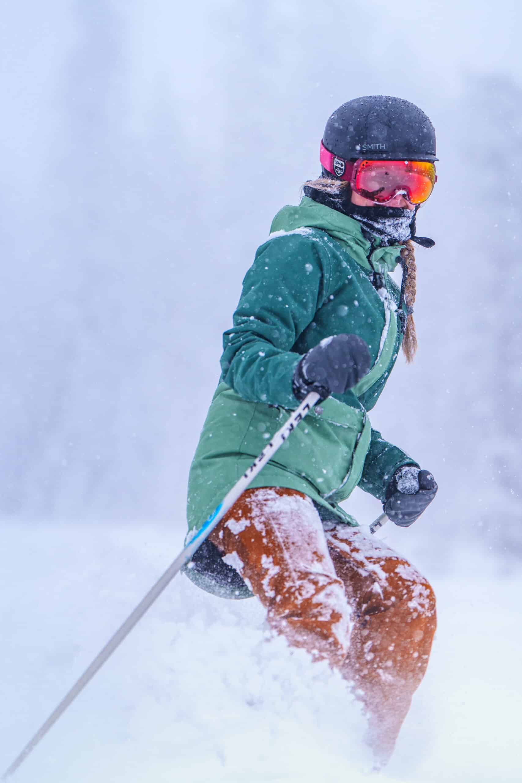 A skier in green on a snow day at Snowbowl