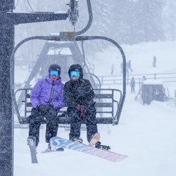 A couple on the Sunset chairlift, snowing