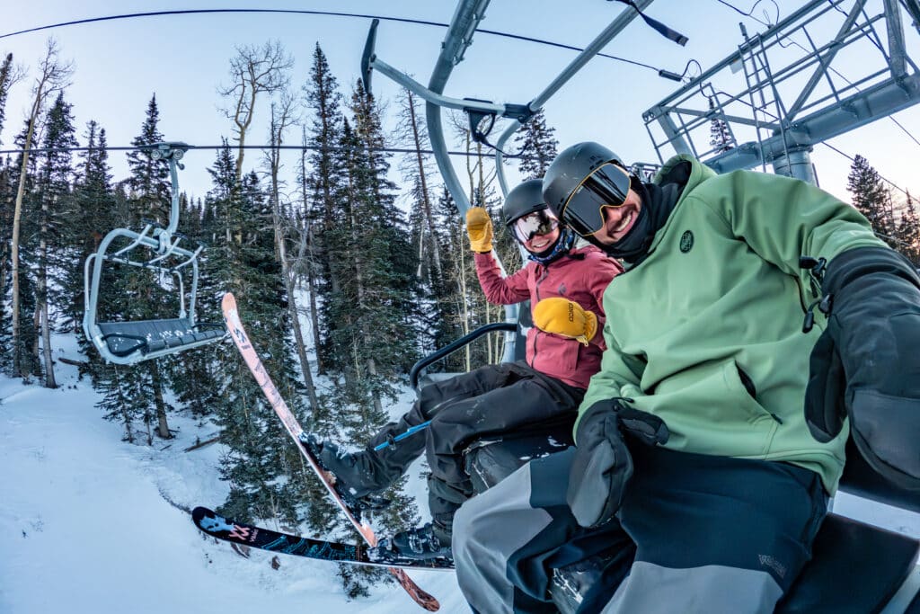 Skier and snowboarder on a chairlift at snowbowl