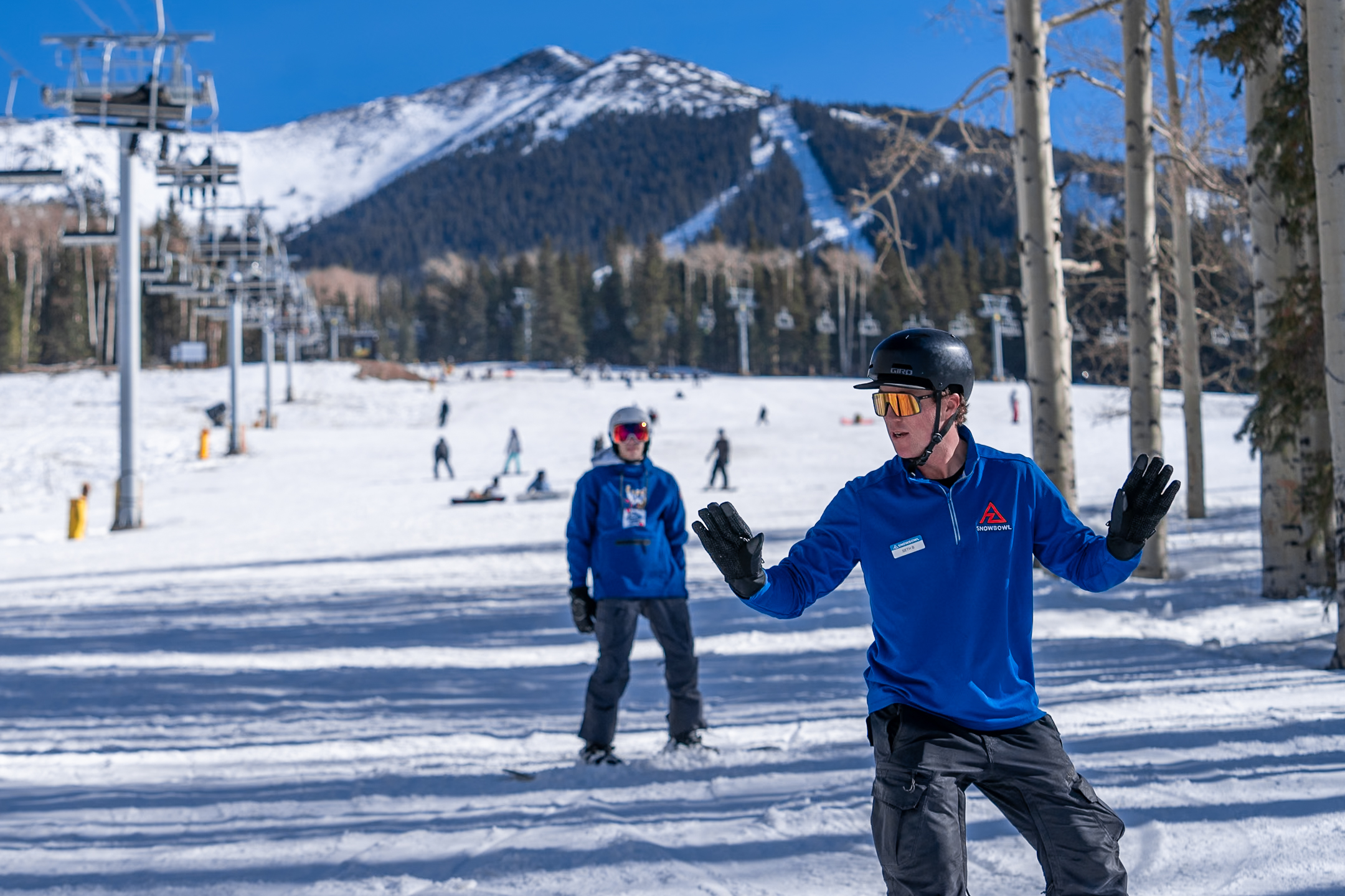 A Snowboard instructor giving a lesson at Snowbowl
