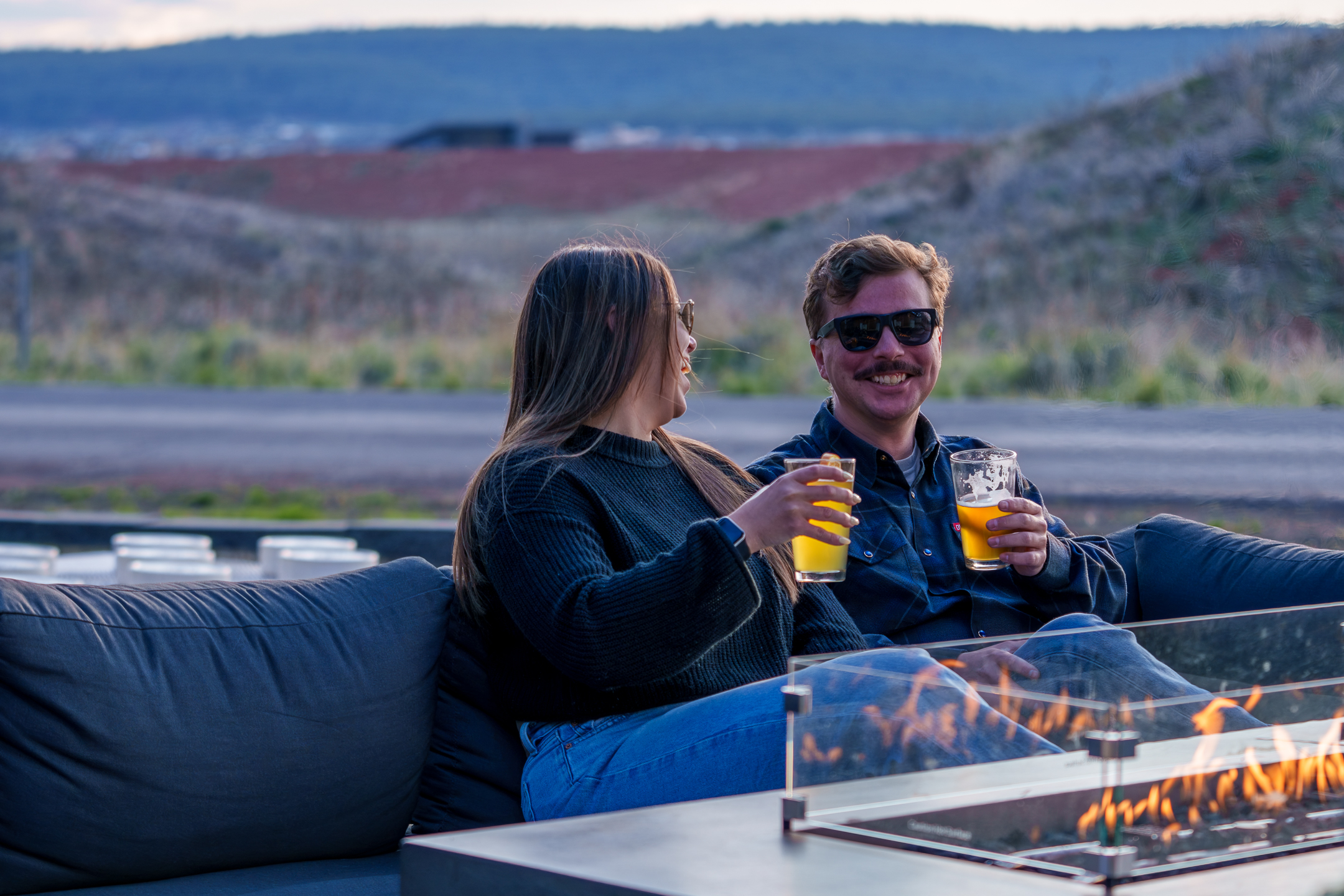 Two guests enjoying the Basecamp back patio and fire place