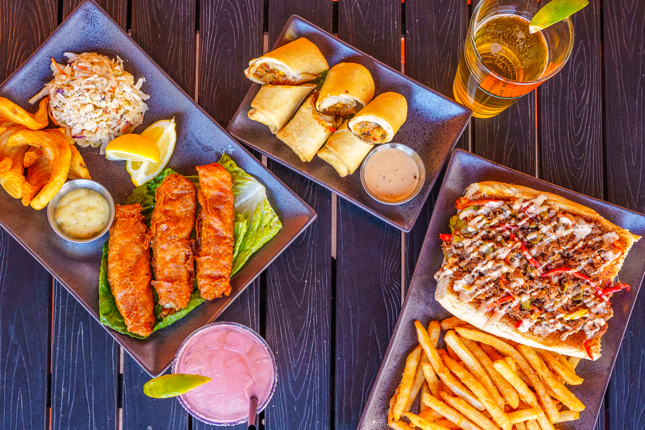 A spread of Basecamp food including fish and chips, Arizona cheesesteak, and more